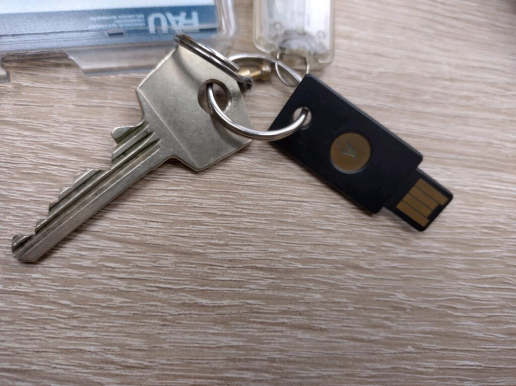 Ein Yubikey hängt mit einem Schlüssel am Schlüsselbund
